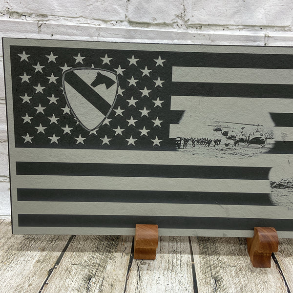 A close up view of the left side of the flag showing the 1st Calvary Division Patch in the union of the US flag. And the helicopters landing and picking up soldiers scene which is in the strips of the flag.