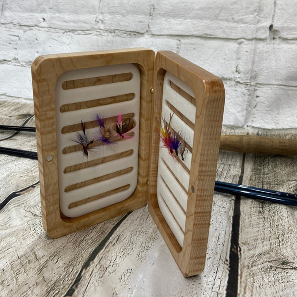This fly box is made with highly figured curly maple wood. Hinged with a barrel hinges, and earth magnets to hold close to give it a sleek look. Fly box can hold up to 80 flies depending on types of flies.. This fly box will show everyone on the water, you love fly fishing and do it in style! This fly box measurements are 4 5/8 inch wide x 6 7/8 inch length x 1 1/8 deep. All fly boxes are finished with Total Boat Halcyon clear varnish.