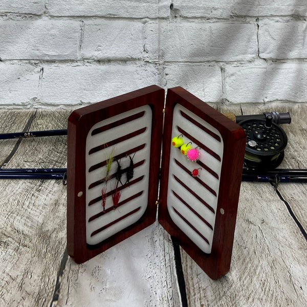 This fly box is made with a beautiful wood called pad-auk. Hinged with a barrel hinges, and earth magnets to hold close to give it a sleek look. Fly box can hold up to 80 flies depending on types of flies. This fly box will show everyone on the water, you love fly fishing and do it in style! This fly box measurements are 4 5/8 inch wide x 6 7/8 inch length x 1 1/8 deep. All fly boxes are finished in Total Boat halcyon clear varnish.