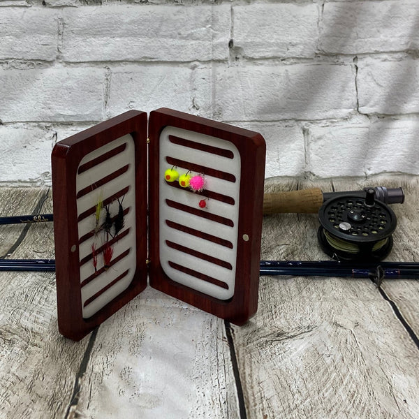 This fly box is made with a beautiful wood called pad-auk. Hinged with a barrel hinges, and earth magnets to hold close to give it a sleek look. Fly box can hold up to 80 flies depending on types of flies. This fly box will show everyone on the water, you love fly fishing and do it in style! This fly box measurements are 4 5/8 inch wide x 6 7/8 inch length x 1 1/8 deep. All fly boxes are finished in Total Boat halcyon clear varnish.
