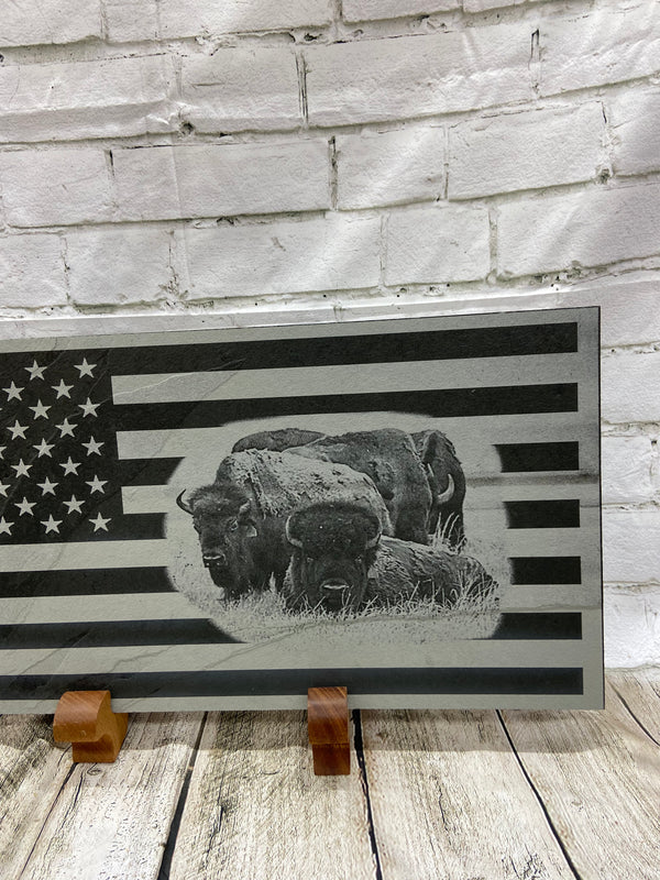 A close up of the right side of the flag and the herd of bison.