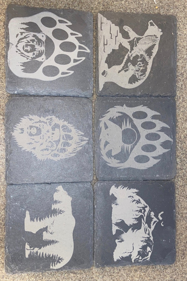 We have 6 laser engraved black slate coasters with bear paws and bears with different scenes within them.