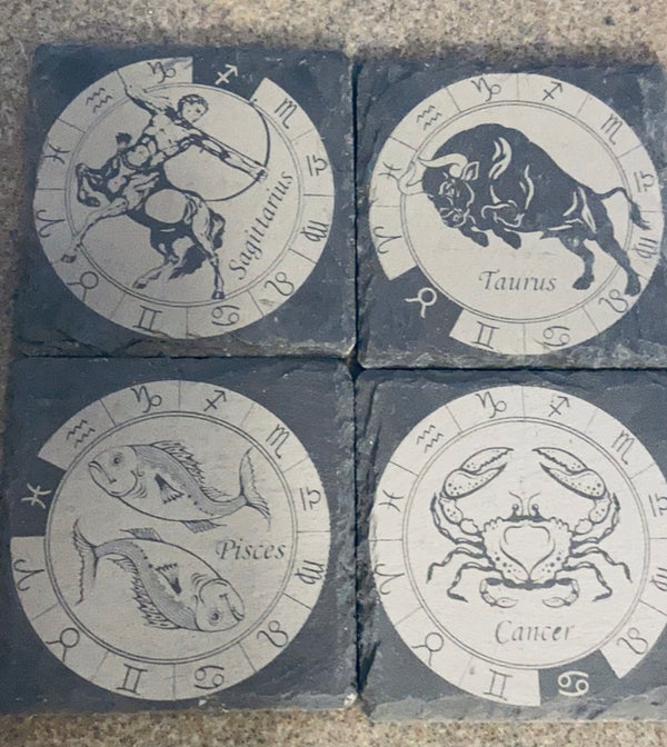 laser engraved black slate coasters of the Zodiac signs Piscies, Sagittarius, Cancer, Taurus