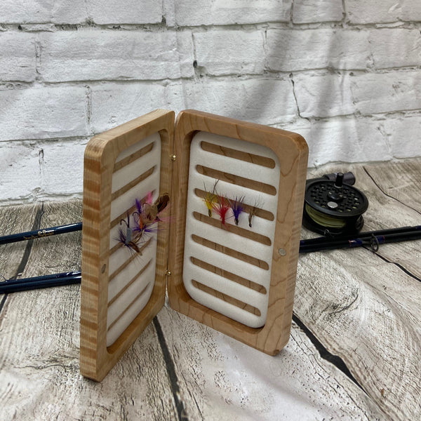This fly box is made with highly figured curly maple wood. Hinged with a barrel hinges, and earth magnets to hold close to give it a sleek look. Fly box can hold up to 80 flies depending on types of flies.. This fly box will show everyone on the water, you love fly fishing and do it in style! This fly box measurements are 4 5/8 inch wide x 6 7/8 inch length x 1 1/8 deep. All fly boxes are finished with Total Boat Halcyon clear varnish.