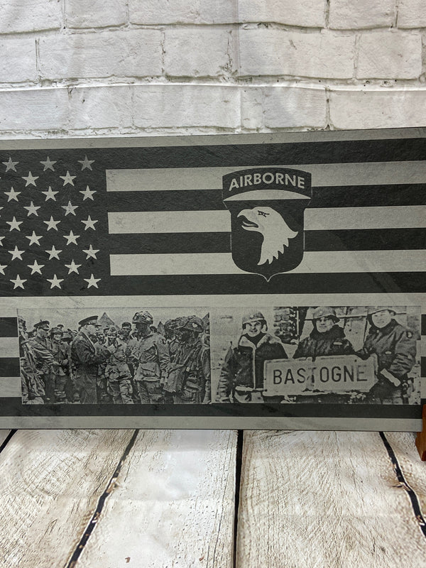 The 101st Airborne Division Patch on the stripes section of the US flag. Along with two scenes for World War 2, one is of President Eisenhower talk to 101st soldiers before they get on their airplanes to jump on D-day. The other is of the 101st Airborne leadership holding the sign for the city of Bastogne. After the Battle of Bastogne during World War 2.