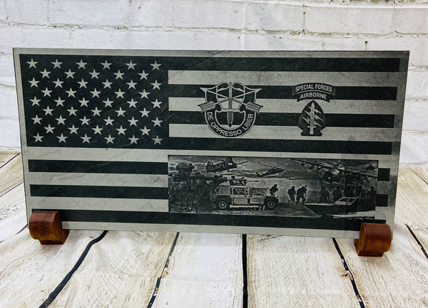 An American flag with the US Army Special Forces patch, crest and a scene with multiple SOF scenes all laser engraved on black slate.